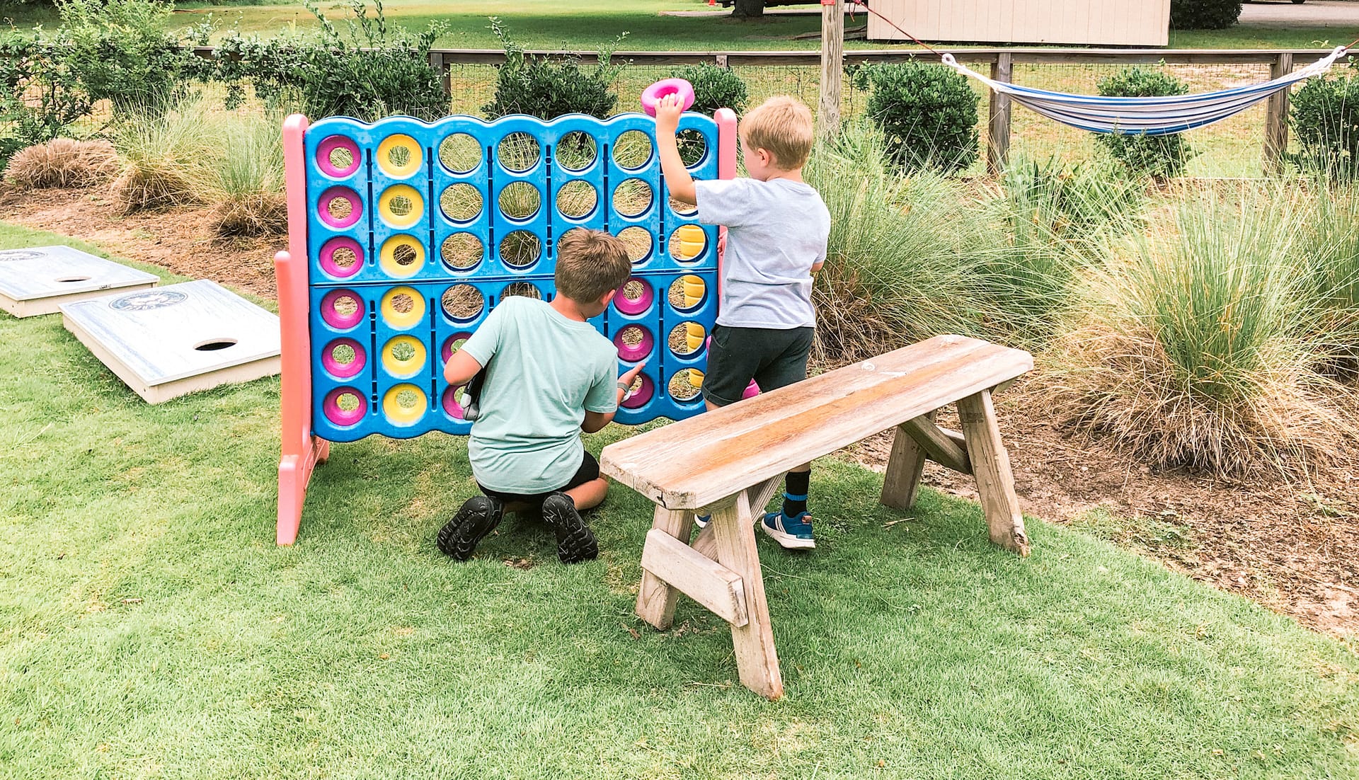 Two boys playing with a giant Connect Four Board