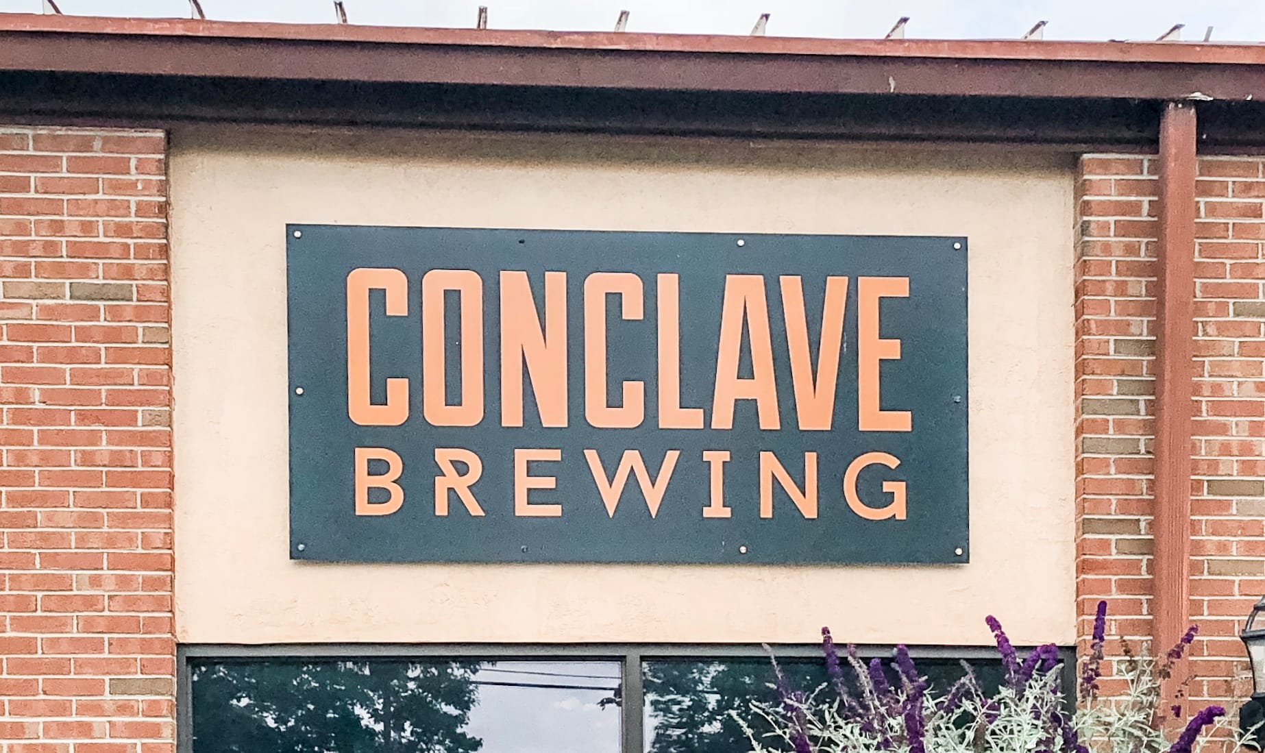 Sign above door that reads Conclave Brewing