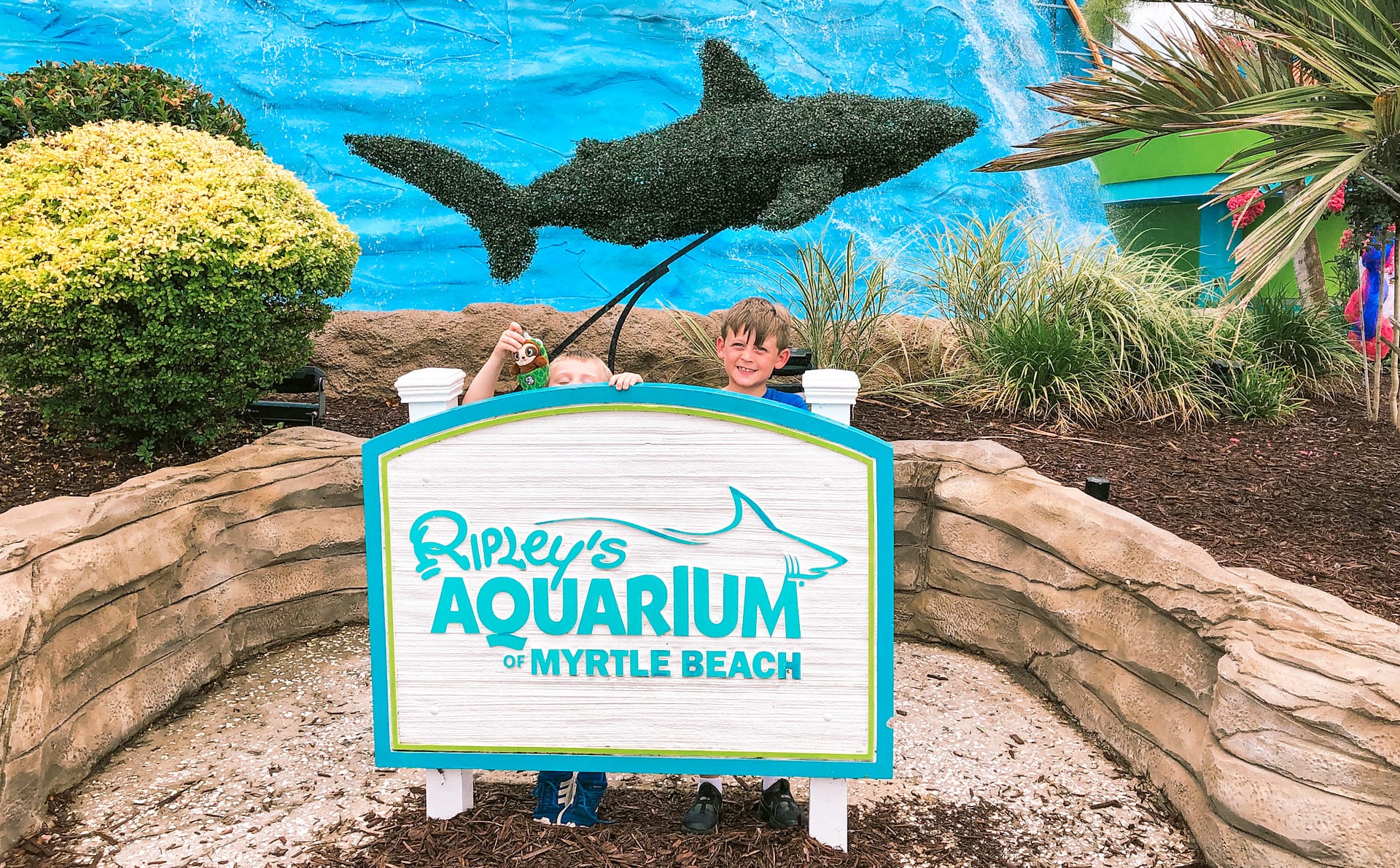 Happy boy standing behind a sign that reads Ripley's Aquarium