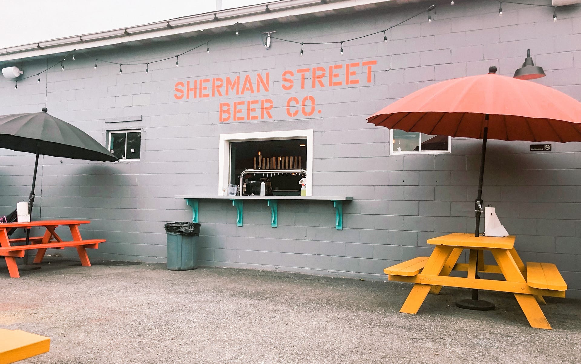 Beer garden take out window paninted sign above window reads Sherman Street Beer Co.