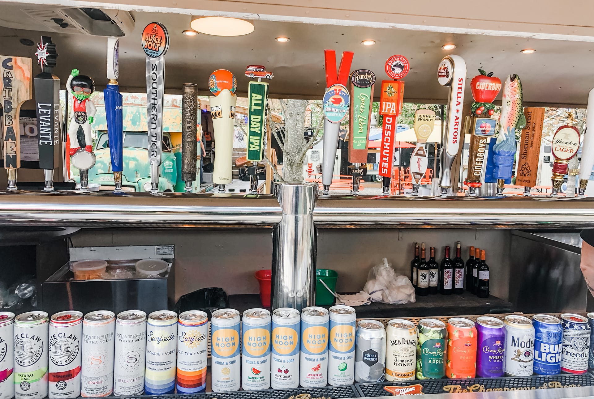 Colorful  beer tap handles and cans displayed below