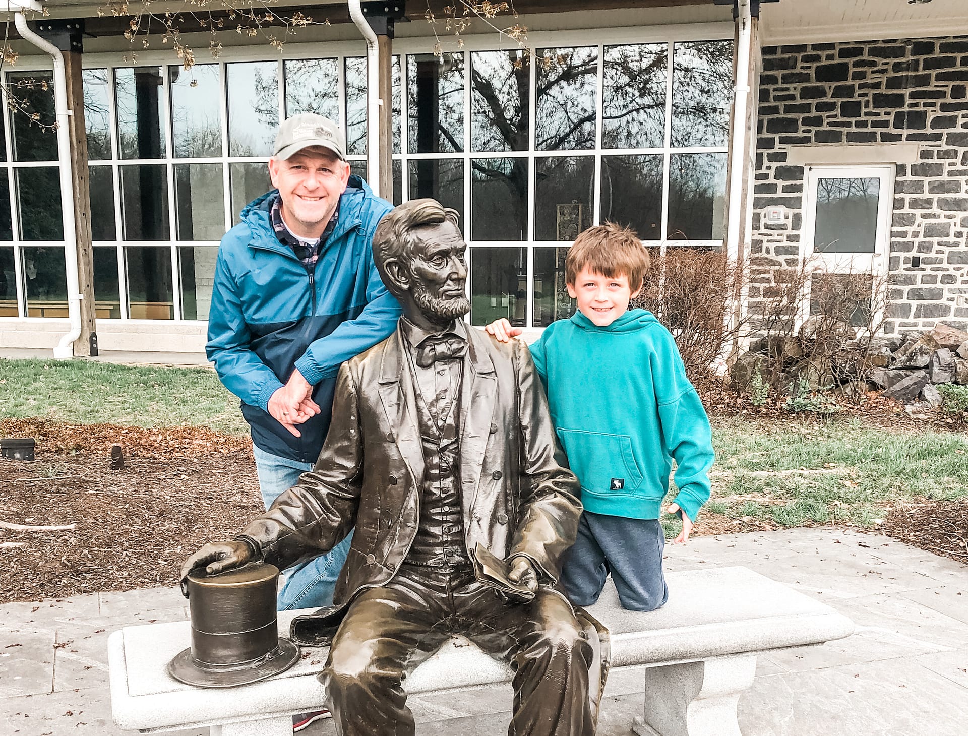 Happy dad and son posing next to a statue of Abraham Lincoln