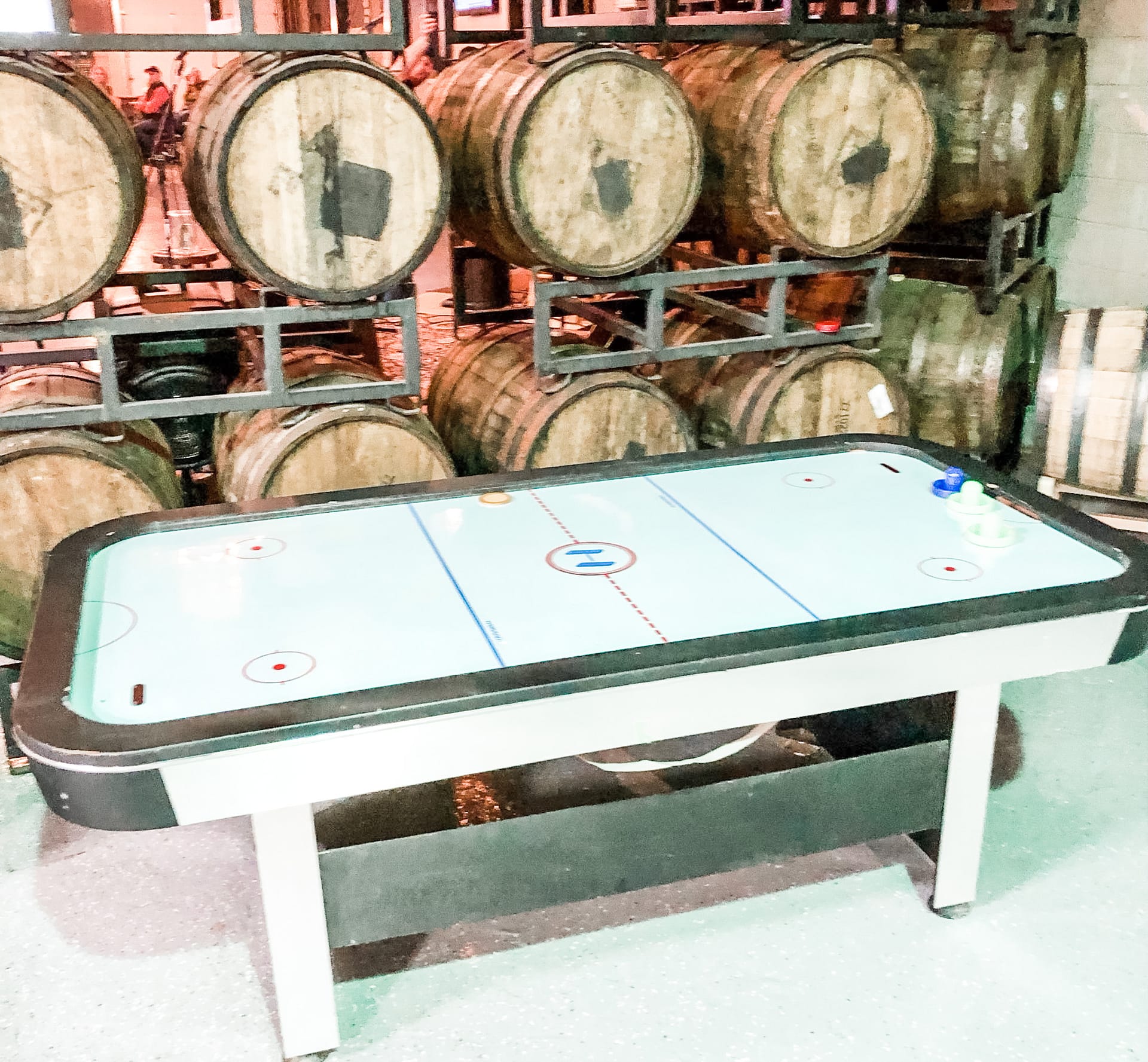 Air hockey table with beer barrels in background