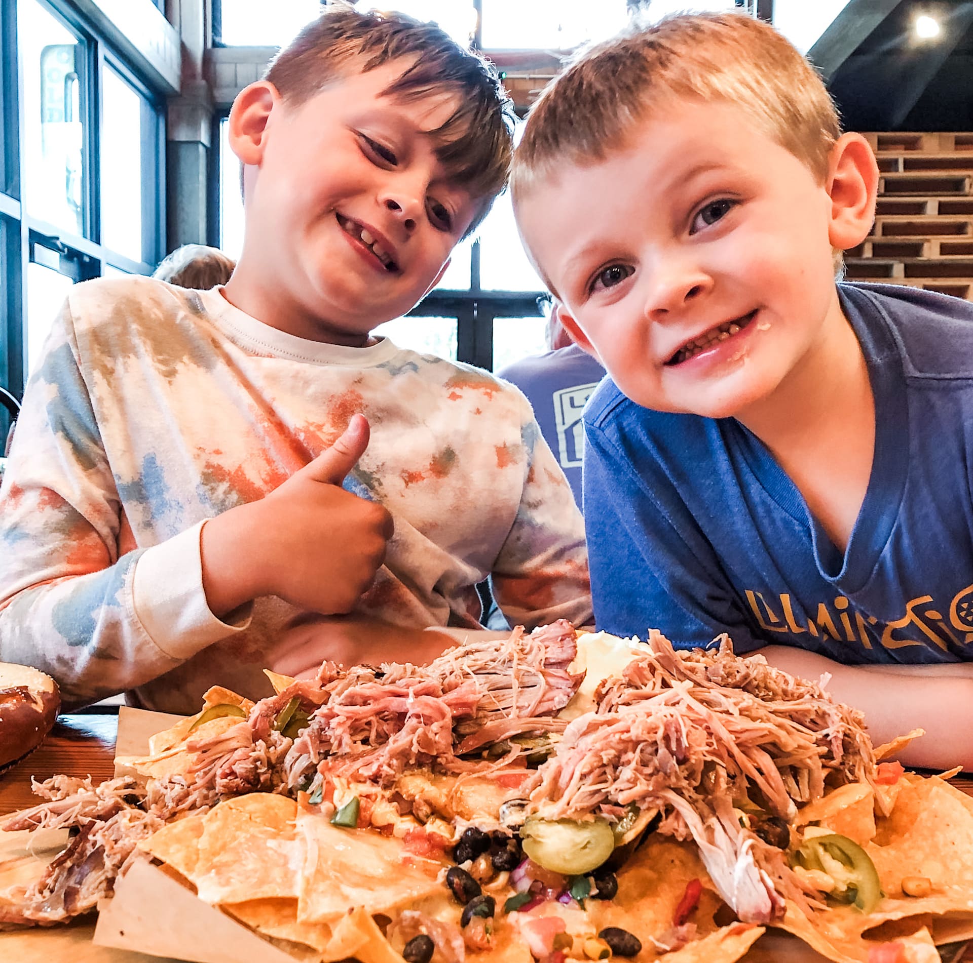 Happy boys posing in front of a plate of nachos